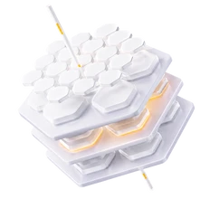 White modular keyboard with hexagonal keys in three stacked layers and a white cable.