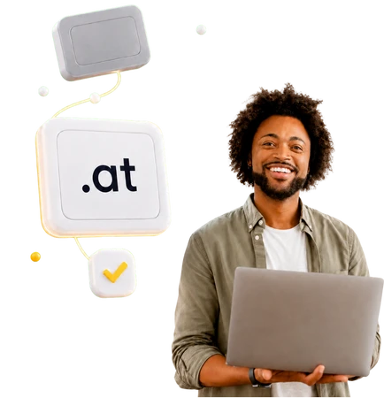Smiling man holding a laptop; floating white tiles, including one showing '.at'.