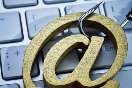 Close-up of a gold '@' symbol on a computer keyboard.